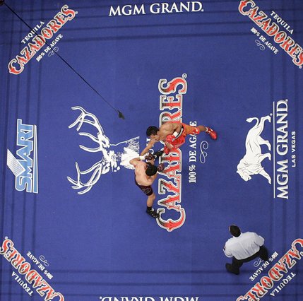 Oscar De La Hoya and Manny Pacquiao trade punches in a 12-round welterweight boxing match at the MGM Grand Garden Arena on Saturday night.