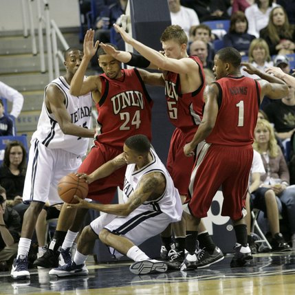The UNLV defense swarms UNR Saturday at the Lawlor Events Center in Reno, Nevada.  UNLV defeated UNR 64-57.