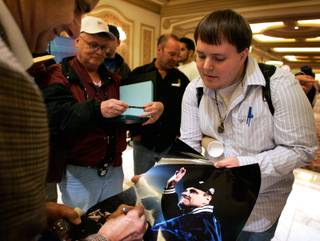 Mark Sherfey, a student from Bowling Green, Kentucky gets an autograph from Joe Torre during the Major League Baseball Winter Meetings at the Bellagio.