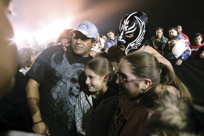 Miguel Lopez Angel Diaz, wearing a mask as his persona Rey Misterio, poses with fans. Wrestlers weren't stingy with their time as admirers lined up for autographs and photos.