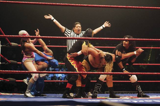 A referee who goes by El Indio calls a stop to a match Saturday. Wrestlers of all types, including some women, performed high-flying action moves and threw in some slapstick comedy.