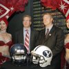 Arizona football coach Mike Stoops (left) and BYU football coach Bronco Mendenhall pose for photos between Las Vegas show girls during a news conference at ESPN Zone inside the New York New York casino on Dec. 9. BYU will face Arizona in the Las Vegas Bowl on Saturday.