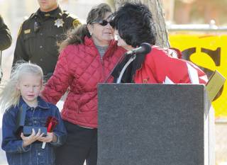 Sandy Heverly, the president of Stop DUI, right, is embraced by Patti Vesely during an anual memorial held Saturday at Sunset Park to remember those who have been lost in DUI accidents. Vesely's daughter Cody was killed by a drunk driver at the intersection of Russel and Lamb in 1997. At left is Vesely's daughter Emma.