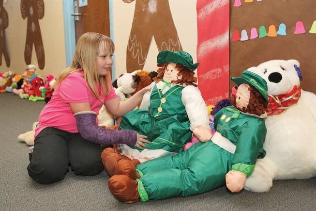 Before the school bell rings at Edna F. Hinman Elementary School, third grader Katlin Hawes places a leprechaun among the other stuffed animals to be donated to children in need or in the hospital.