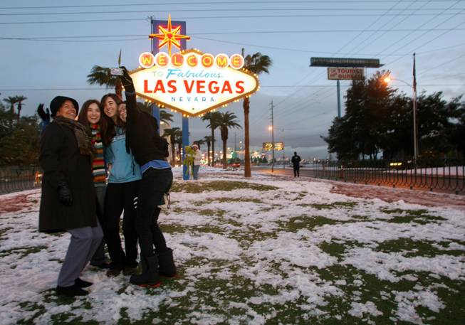Karen Schroeder, left, of Henderson and her daughters Emily, 17, Erika, 20, and Erin, 22, take a photo Thursday morning. A rare snowstorm blanketed the Las Vegas Valley on Wednesday, delaying flights, causing widespread fender benders and canceling school. More than 6 inches of snow fell in parts of the valley, forecasters said.