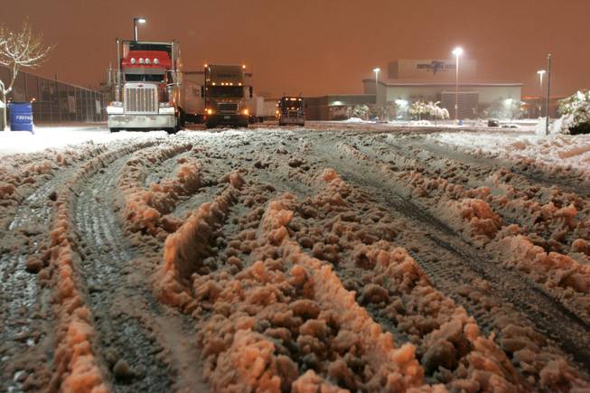 Trucks wait in the parking lot of Foothill High School after U.S. 95 was closed at College Drive Wednesday.