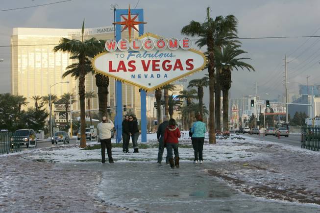 People pose on The Las Vegas Strip Thursday. A rare snowstorm blanketed the Las Vegas Valley on Wednesday, delaying flights, causing widespread fender-benders and canceling school. More than 6 inches of snow fell in parts of the valley, forecasters said.