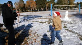 Kevin Martin and his 7-year-old Zachary Martin test out their winter gear with a snowball fight at Sunset Park Thursday.