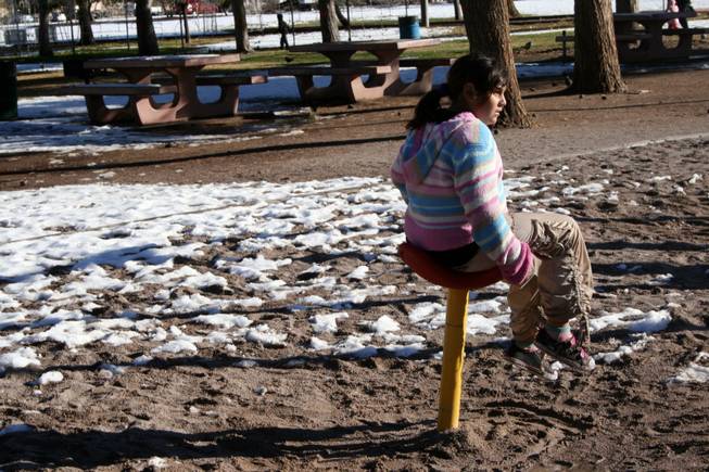 Paula Martinez, 10, enjoys the playground at Sunset Park Thursday. She and her cousins had been building a snowman, but stopped to play because their bare hands got cold.