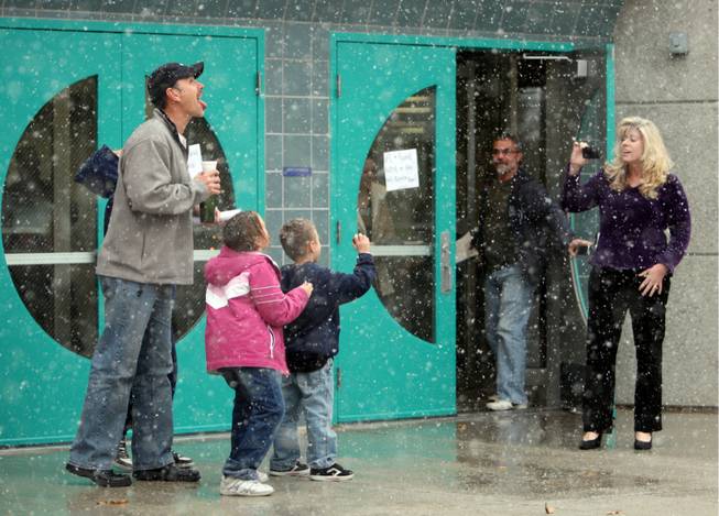 Richard Elliott tries to catch a snowflake on his tongue as teacher Melinda MacLean takes a video of his family Wednesday at Bartlett Elementary School in Henderson.