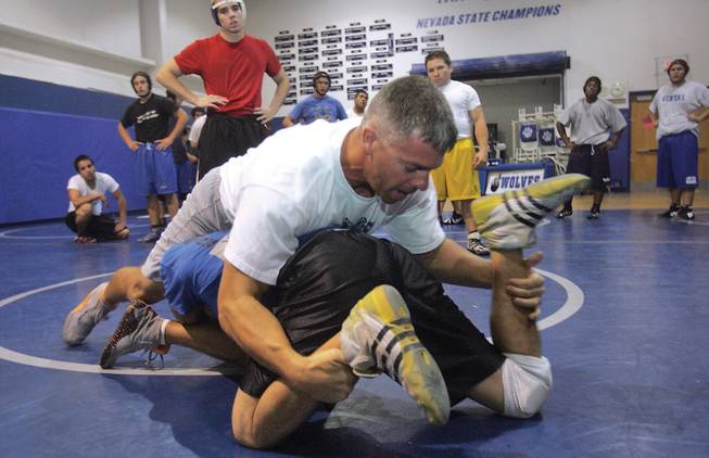 Mark VanDamme, the new head wrestling coach at Basic, demonstrates a wrestling move with Mark Bleuze during wrestling practice.