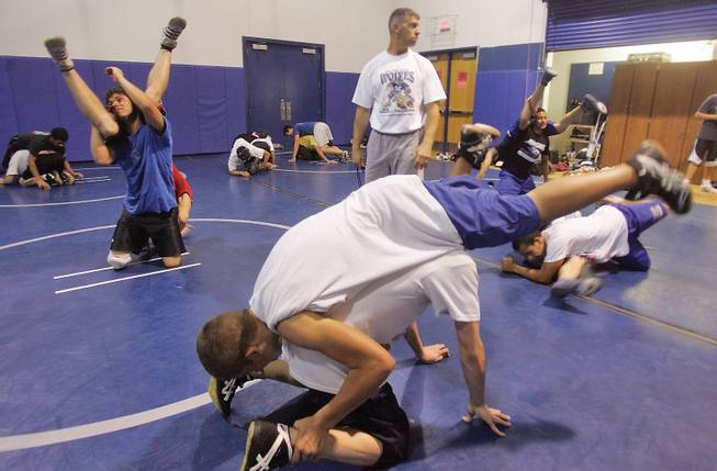 Mark VanDamme, the new head wrestling coach at Basic, walks amongst his team as they practice a few moves.