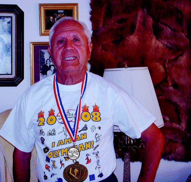 Sun City resident Ernest Arze, 80, wears a medal he won for tennis.