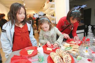 From left, Sausha Goaves, 8, Valan Mallory, 5, and her sister Aliysa, 11, decorate cookies during an arts and crafts workshop at the Plaza Gallery, 223 S. Water Street, during the Third Thursday Arts Walk.