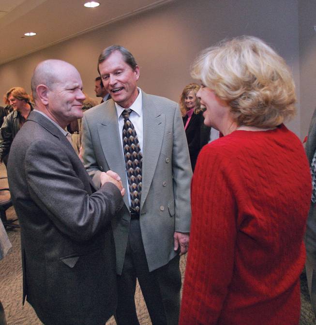 Clark County Commissioner Bruce L. Woodbury, center, is greeted by Dick Wimmer, left, deputy general manager for the Las Vegas Valley Water District, and long time colleague Judie Brailsford, right, during a farewell celebration acknowledging Woodbury's years of service on the commission held at the Clark County Government Center Dec. 17. His current term of office expires the first Monday in January.