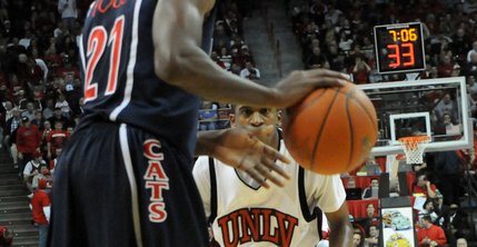 Oscar Bellfield of UNLV is focused on defense as Kyle Fogg of Arizona brings the ball up the court Saturday. The Rebels defeated the Wildcats 79-64.