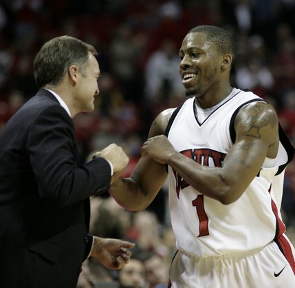 A happy Wink Adams is greeted by head coach Lon Kruger as Adams is done for the day with 25 points. The Rebels defeated the Wildcats 79-64.