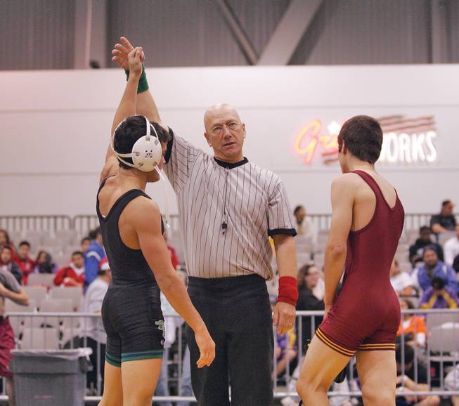 Referee Mike Guerino annouces Mason Saldana of Green Valley winner after defeating Daniel Flores of El Modena High School in California wrestle in a 121 lbs. meet during the Las Vegas Holiday Classic Wrestling Tournament at the Las Vegas Convention Center on Dec. 19.