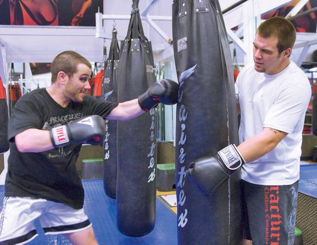 MMA fighters Marco (left) and Danny Scoalri work with a heavy bag during training  at the Las Vegas Athletic Club in Las Vegas.