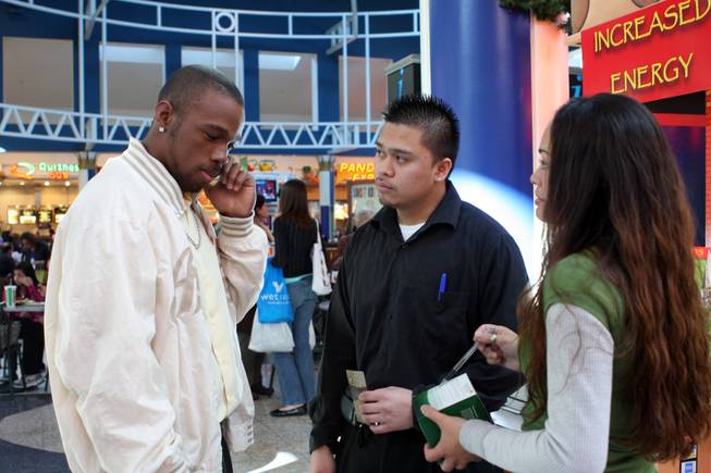 Demonte Haynesworth, left, takes a break from shopping on December 26, 2008 and while searching for a seat in the Galleria Mall food court he his approached by Danilo Agapito and Timisha Carter at the Green Tea HP kiosk.
