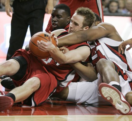 UNLV's Kendall Wallace, left, and Louisville's Jerry Smith, right, battle for a loose ball during the second half. Wallace's teammate, Brice Massamba, looks on in the background.  UNLV won the game 56-55. 