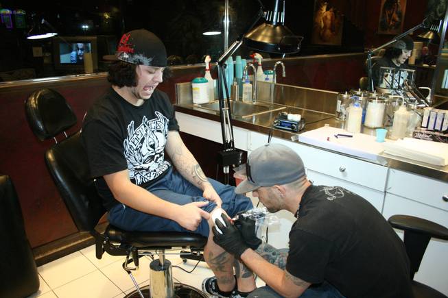 

<p>11:40 p.m.: Hart and Huntington tattoo artist Josh Sutcliffe has a coworker add some color to his knee cap on New Year's Eve.</p>

<p>The 24-year-old already had 17 tattoos but he figured one more wouldn't hurt. He chose the logo of his favorite rock band, the Red Hot Chili Peppers, as the design.</p>

<p>While the motif was a contrast from the mostly Asian-inspired ink Sutcliffe already had (he has a thing for koi fish, apparently) he thought the design was appropriate.</p>

<p>"That's my favorite band," he said. "I'm super influenced by them."</p>
