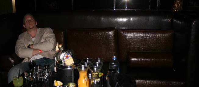 2:45 a.m.: A lone soldier guards his bounty of bottle service booze at Playboy Club. 