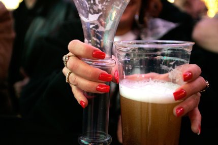  A woman holds on to two beers during Tribute Palooza, the New Year's Eve party at the Fremont Street Experience in downtown Las Vegas Wednesday. 