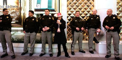 Antoinette Wentworth of Namibia, Africa stands with Metro Police officers on duty during Tribute Palooza, the New Year's Eve party at the Fremont Street Experience in downtown Las Vegas Wednesday. 