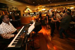 Lounge musician Bobby D. performs for a dancing crowd during New Year's Eve festivities at the Round Bar inside the JW Marriott Resort in Summerlin Wednesday, Dec. 31, 2008.