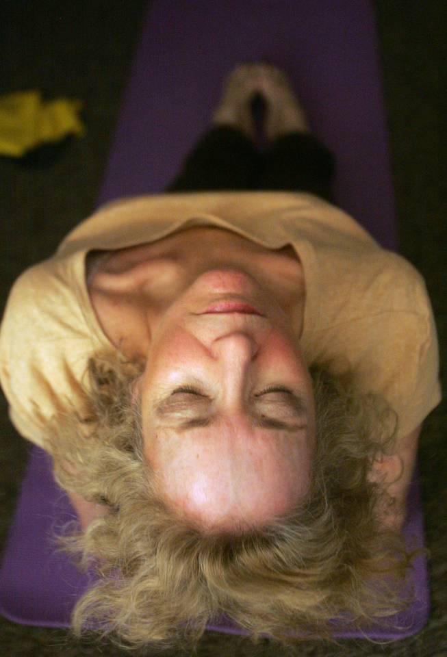 Carol Cohen leans back in meditation during a special holiday yoga class at the Paseo Verde Library.