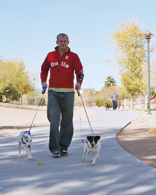 Roger Grandgenett walks his dogs, Truman and B.J., along the trails in Summerlin.