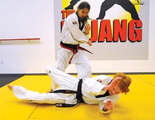 Soraya Peron tosses Geordie Ryder to the mat during a self-defense demonstration inside the martial arts studio, The Dojang.