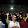 Matthew Stutzman, left, and Jeff and Teresa Sowers watch the BCS championship game in 3-D. The audience was told the special 3-D glasses work best worn upside down.