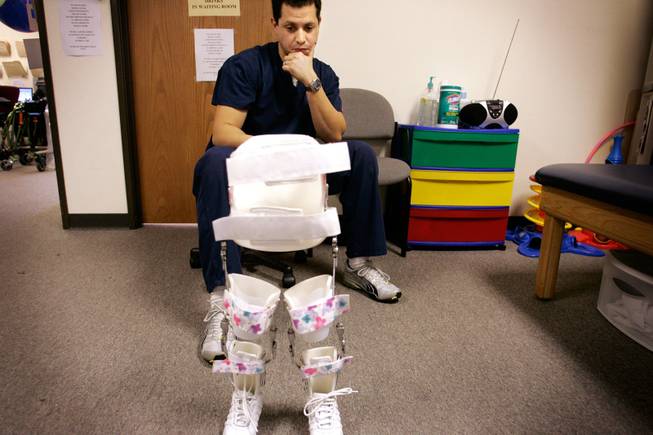 Physical therapist Edwin Suarez looks at a leg brace to make sure it is straight for a pediatric patient at his office in Las Vegas on Tuesday, Dec. 23, 2008. Suarez has expanded his practice from strictly pediatric to adult physical therapy because it is more lucrative, but he fears he cannot continue to see patients with Medicaid insurance because the reimbursement rate was reduced drastically in the last round of budget cuts. 