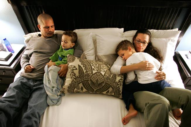 Phil and Rachelle Reynolds watch an educational television program with their sons Sebastian, 4, and Eli, 2, before bedtime for the boys at their home in Henderson on Tuesday, Dec. 30, 2008. Both Sebastian and Eli have been diagnosed with autism and the Reynolds have struggled financially with their specialized care. 