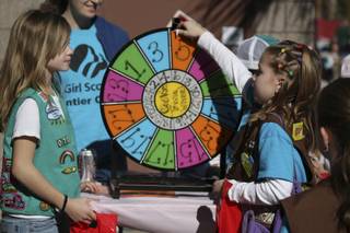 Confident in her cookie knowledge, Jayalyn Buckner, right, turns the cookie trivia wheel after receiving instructions from Nicole Taylor at Henderson Troop 70's booth at the Girl Scouts Cookie Kickoff Carnival Saturday at the Girl Scouts Frontier Council's Training and Service Center.
