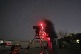 Retired school principal Billy Chapman looks through a telescope during a star gazing party at Red Rock Canyon Saturday.