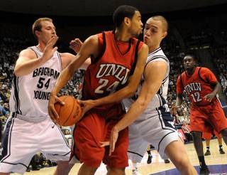 Rene Rougeau looks for the open man as the BYU defense swarms him on Wednesday as UNLV took on BYU at the Marriott Center in Provo, Utah. The Rebels defeated the Cougars 76-70.