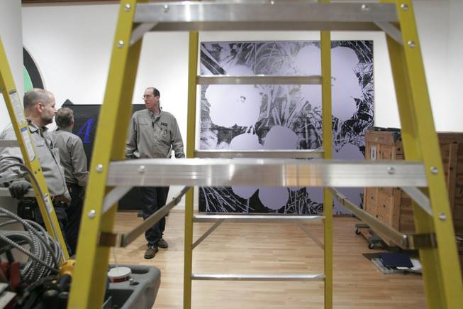 Andy Warhol's "Flowers" waits to be hanged Wednesday at the Bellagio Gallery of Fine Art. Getting it into the gallery required cutting a hole in the wall of the gift shop and removing its glass doors.