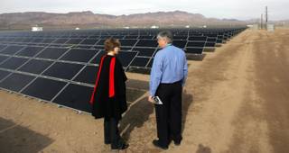 Yvonne Szymczak, left, and Brok Armantrout look at more than 167,00 solar modules over 80 acres of land at El Dorado Valley at Sempra Energy's new El Dorado Energy Solar facility on Thursday.