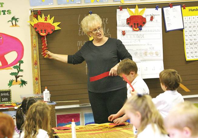 Meadows kindergarten teacher Linda Verbon demonstrates to her class how to make a dragon head out of construction paper in preparation for the school's annual Chinese New Year event.