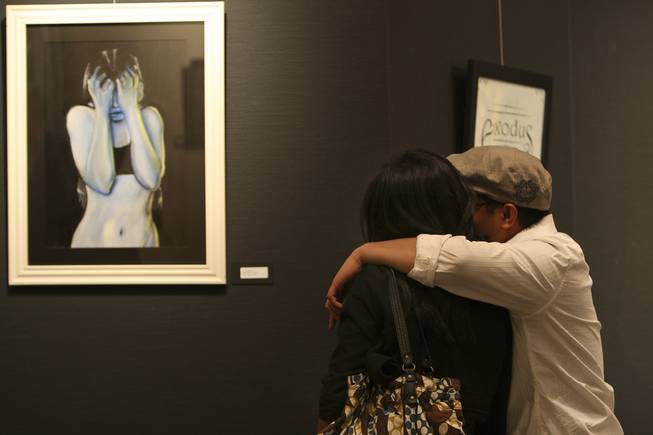 Arianne Kadiz and Rick Quemado, right, stop to admire artist Jordan Gregory's "Self Portrait in Pastel" Thursday during the annual Juried Student Show at the Art Institute of Las Vegas.