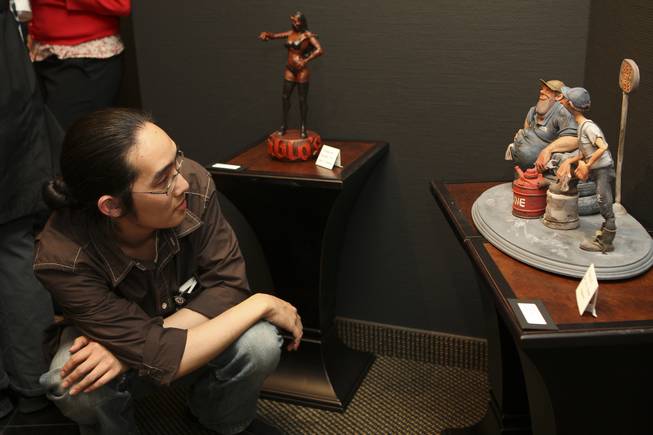 Game art design student Brandon Lin studies the intricate details of the clay sculpture "Harely & Earl" by artist Mariya Walker during the annual Juried Student Show Thursday at the Art Institute of Las Vegas.  Walker's sculpture won first place in the competition.
