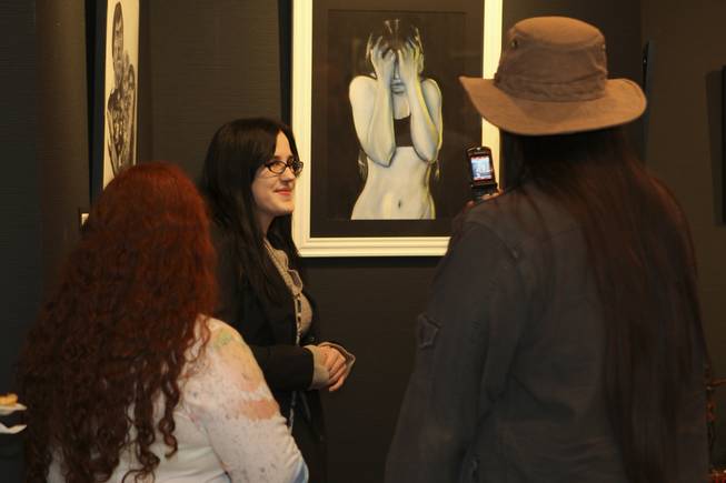 Media arts and animation artist Jordan Gregory poses as her brother, Julian Gregory, right, and sister-in-law, Mande, as they take a photograph of her next to her "Self Portrait in Pastel" during the annual Juried Student Show at the Art Institute of Las Vegas.