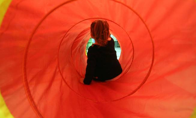 Destiny Cobian, 2, tries out a tunnel toy at Morrow Elementary School's recycling sale Friday. Put on by the Gifted and Talent  Education students, the sale items were collected from all around the school.