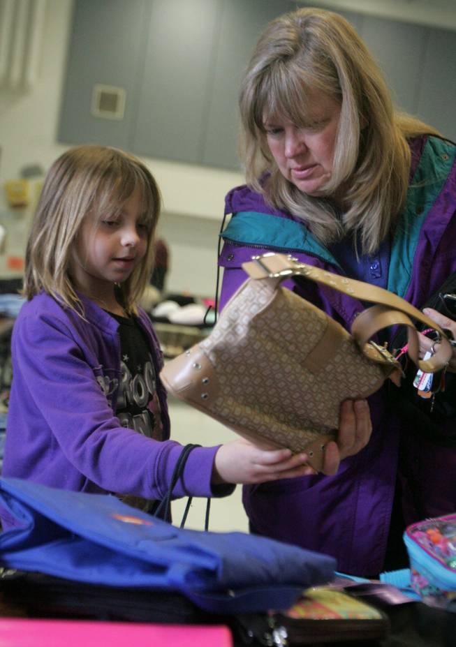 Danielle, 7, left, and Janice Thurston look through a pile of purses at the recycling sale at Morrow Elementary School Friday. The sale was put on by the Gifted and Talented Education students.