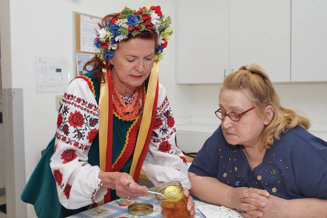 Teaching a 3,000-year tradition, instructor Joy Brittan, left, illustrates dying techniques to Dee Poya, 65, during a Ukrainian Easter egg craft class held at the Henderson Senior Center Tuesday.