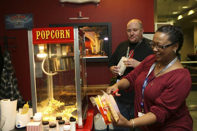 Help desk coordinator Rosalind Searcy makes a new batch of popcorn for facilities assistant Richard Day in the reception area. A Dance Dance Revolution machine, free popcorn and free books greet visitors in the lobby of the Henderson-based online retailer.