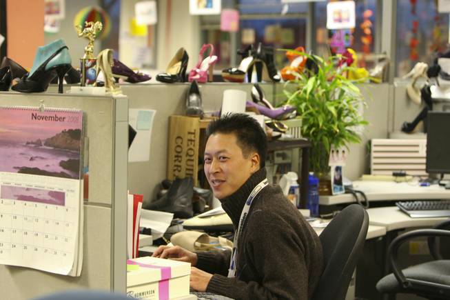 Surrounded by stiletto heels, private label buyer Charles Kim works at his desk at the corporate offices of Zappos.com in Henderson. The online retailer's relaxed, fun-loving and close-knit family atmosphere has won over employees, investors and industry watchers alike.
